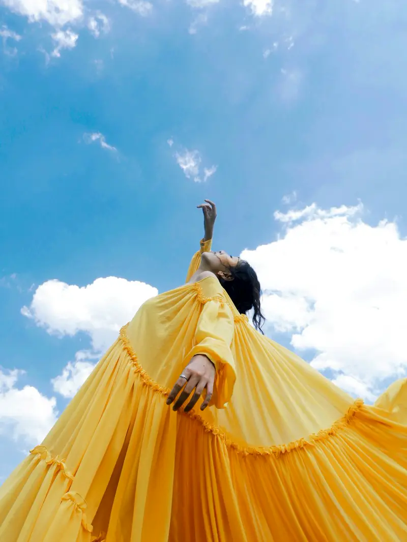 @droplabel — Yellow tiered dress against the sky